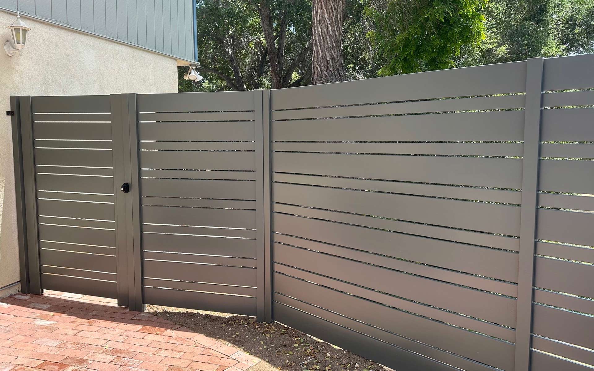 Aluminum slat fence and matching gate on a residential property line
