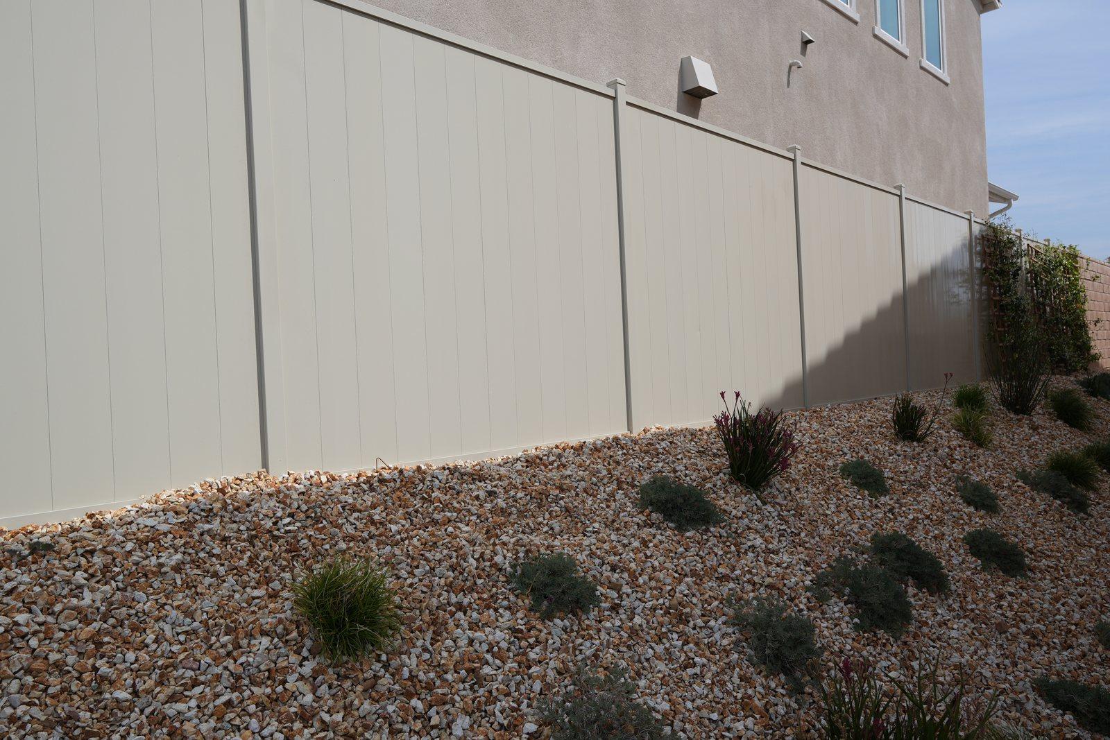 Aluminum privacy fence with a wide gravel clearance at the base