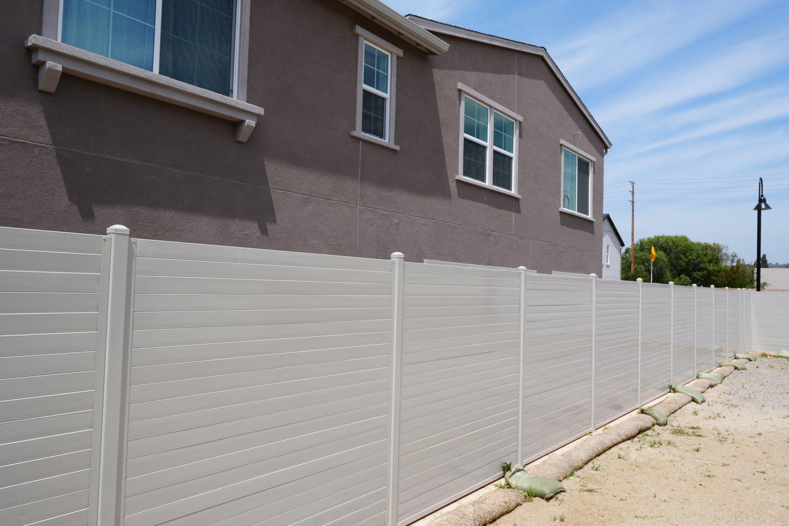 Full-height ribbed steel privacy fence running alongside a home in Santa Paula