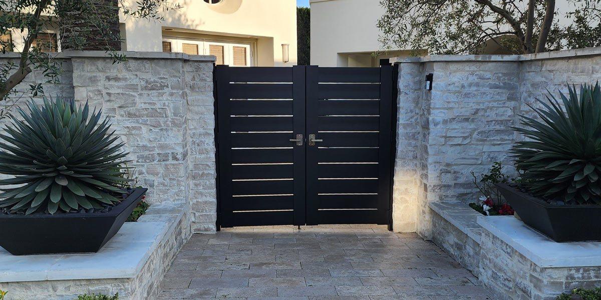Aluminum slat entry gate between stone walls